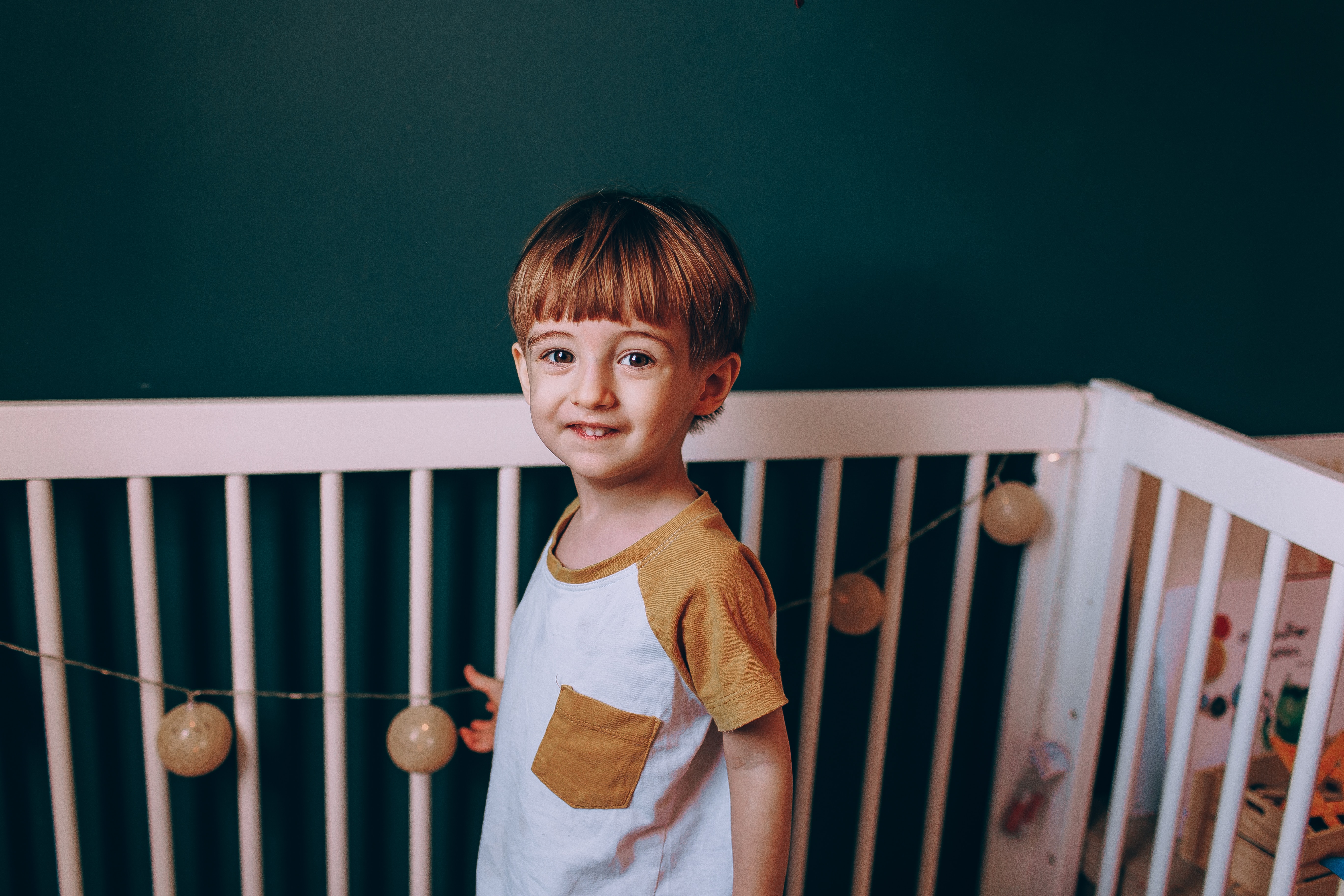 Toddler standing in his crib, illustrating how sleep needs shift from baby to toddler stages